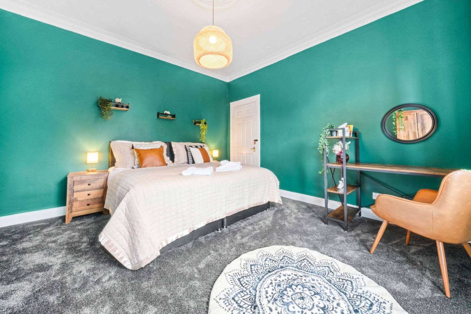 Bright bedroom with turquoise walls, white bed, wooden nightstand, and mid-century chair