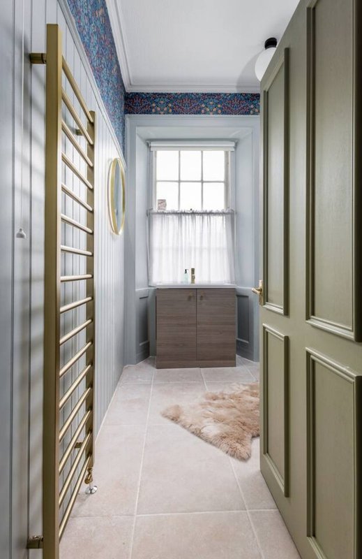 Bright bathroom hallway with window, heated towel rail, chest of drawers and fluffy rug