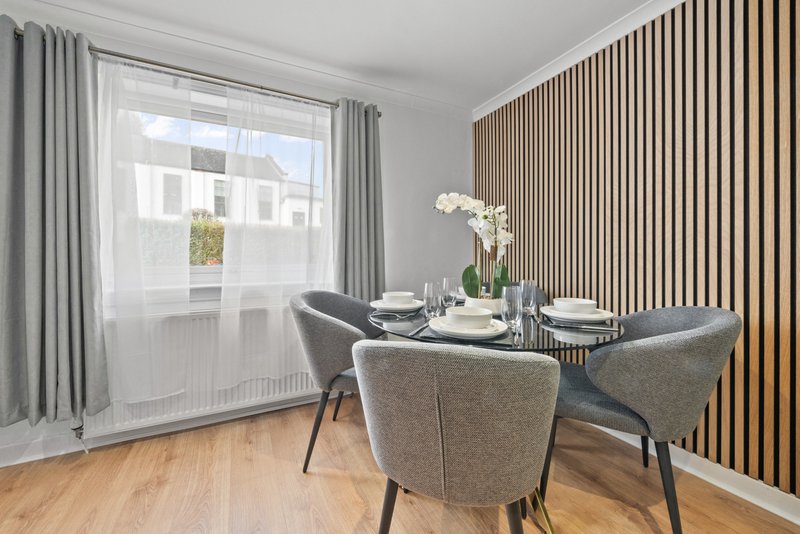 Modern dining room with table, grey chairs, wooden floor and large window