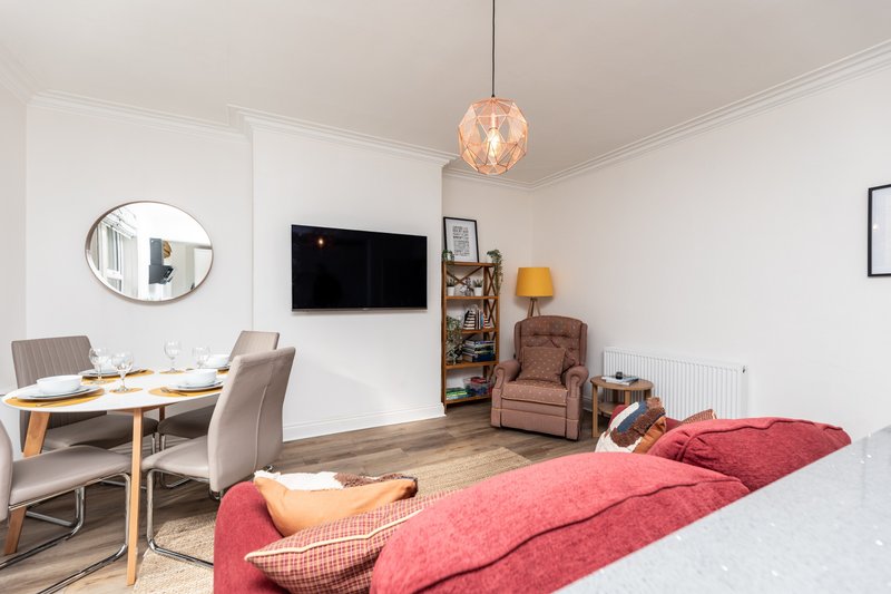Studio bedroom with bed, dining table, TV, armchair and pendant lighting