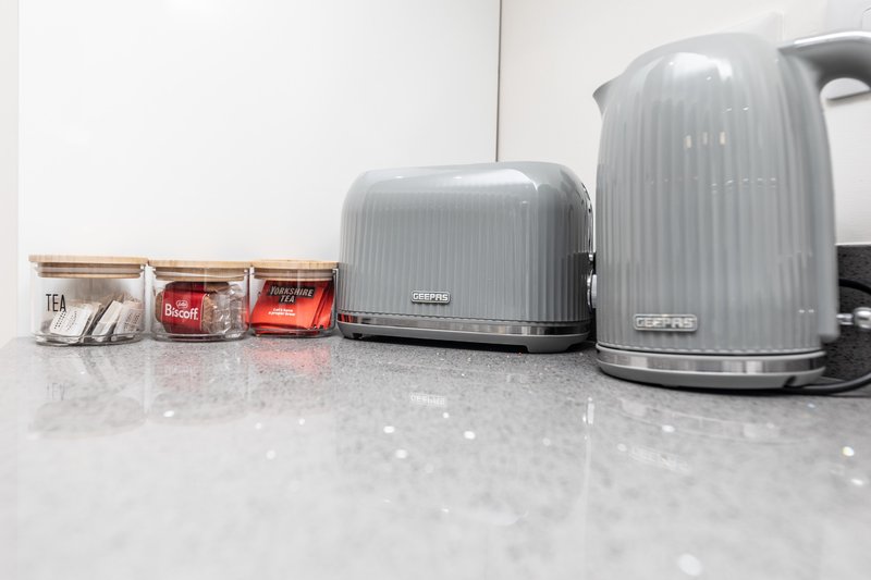Kitchen counter with grey kettle, toaster, and tea storage containers