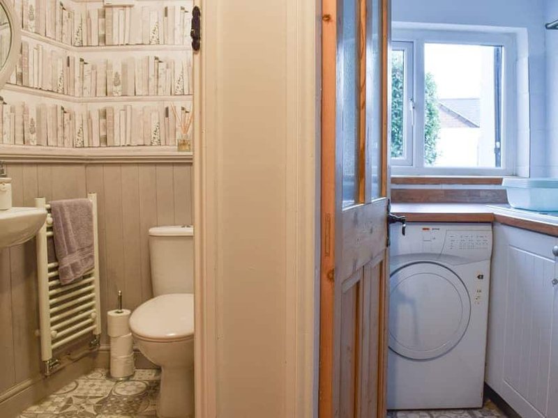 Downstairs cloakroom and Utility Room with washing machine, tumble dryer and kitchen sink.
