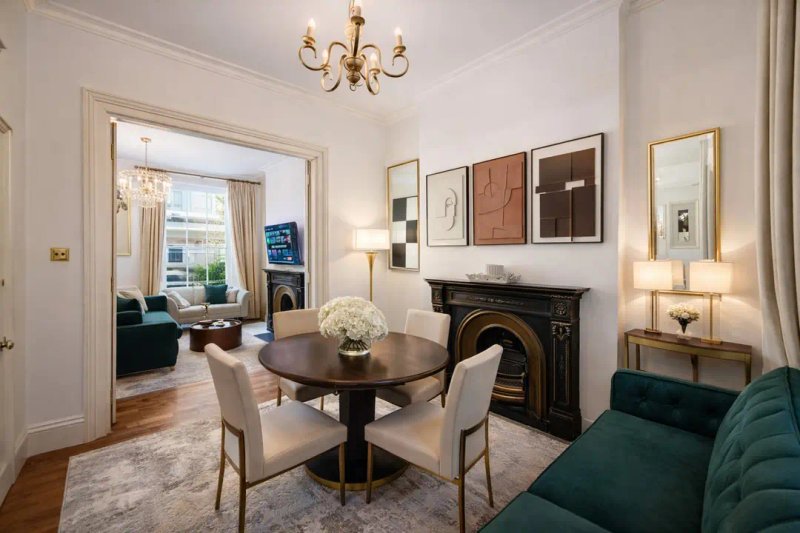 Elegant dining room with round table, fireplace, chandelier, and modern wall art