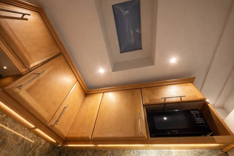 Kitchen with wooden cabinetry, recessed lighting, and built-in appliances