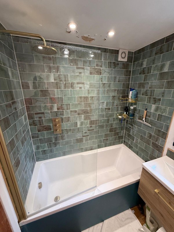 Modern bathroom with tiled shower enclosure, white bathtub, and recessed ceiling lights