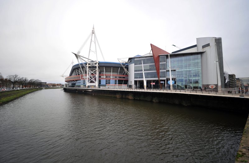 Waterfront view of modern building complex with distinctive architectural features along canal