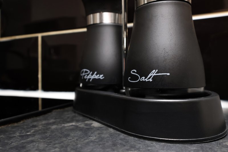 Modern kitchen counter with black salt and pepper shakers on holder