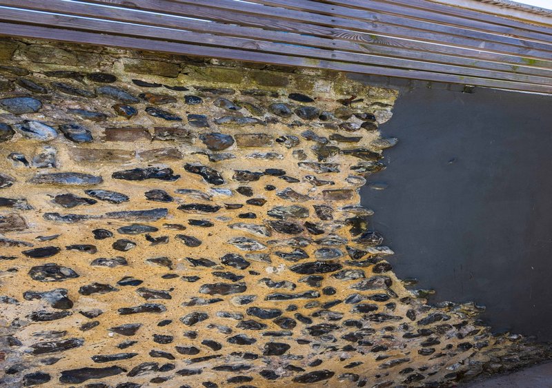 Exterior stone wall with dark slate cladding and weathered surface detail