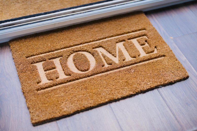 Natural coir doormat with 'HOME' text at property entrance