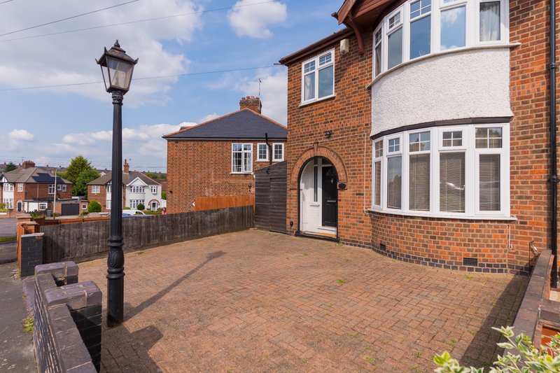 Brick semi-detached house with driveway, front entrance and street lamp
