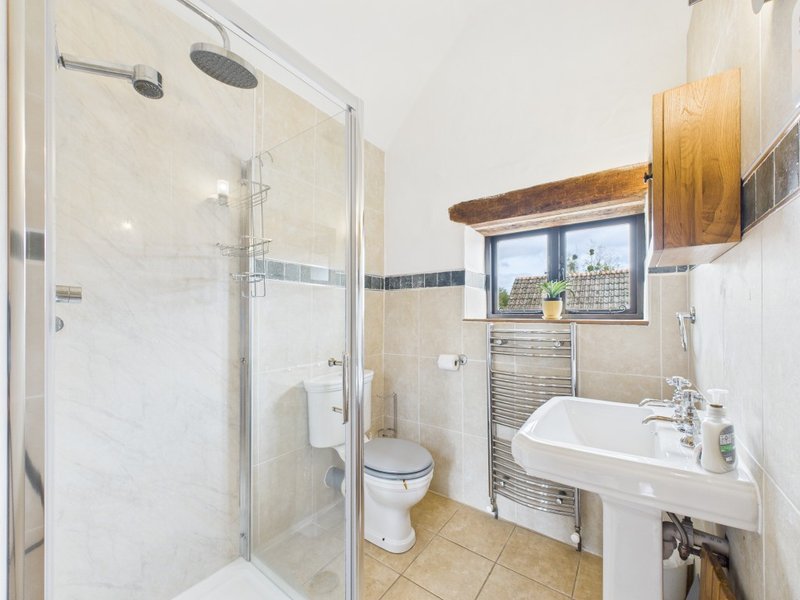Bathroom with walk-in shower, toilet, sink, heated towel rail and window