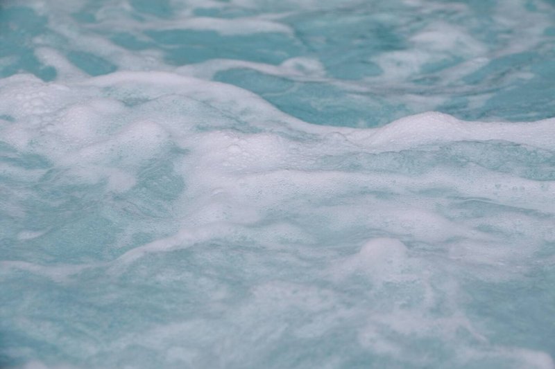 Shallow turquoise water with white foam waves and ripples