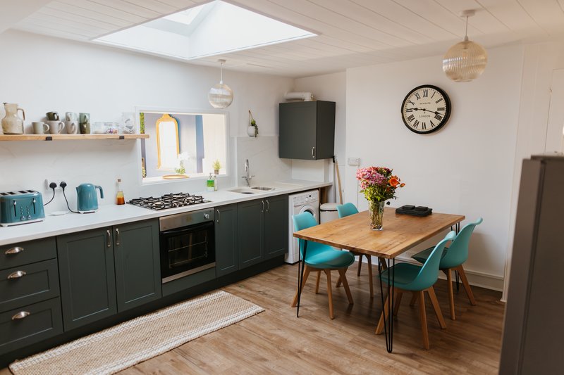 Modern kitchen with all the cooking and dining utensils needed. A hatch opens the space to the lounge for easy conversation and connection