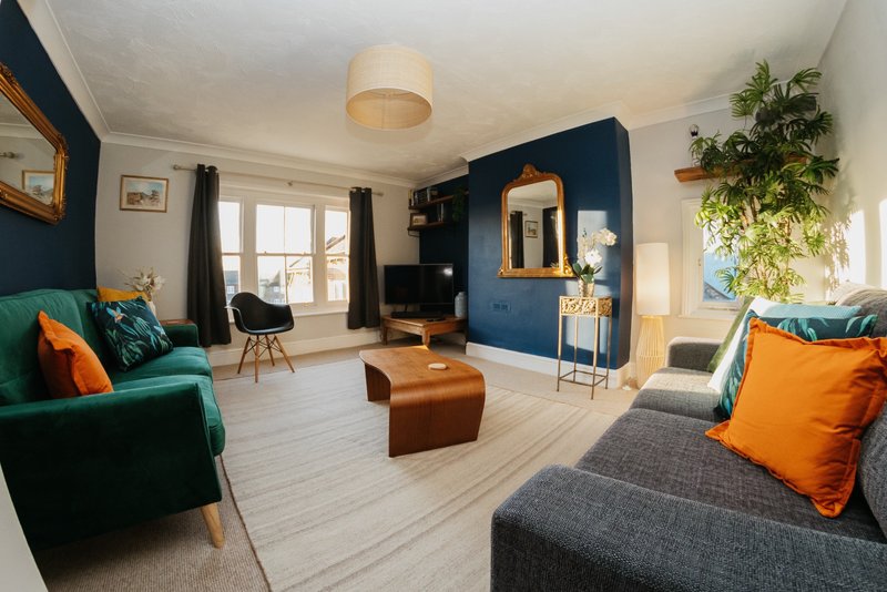 Bright and spacious living room with two settees and smart TV