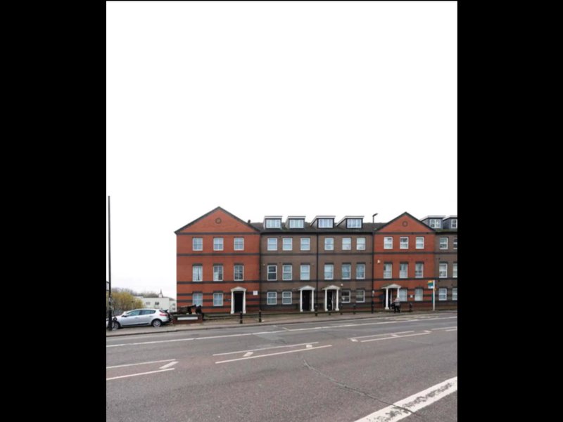 Red brick period buildings with multiple floors and storefronts on street frontage