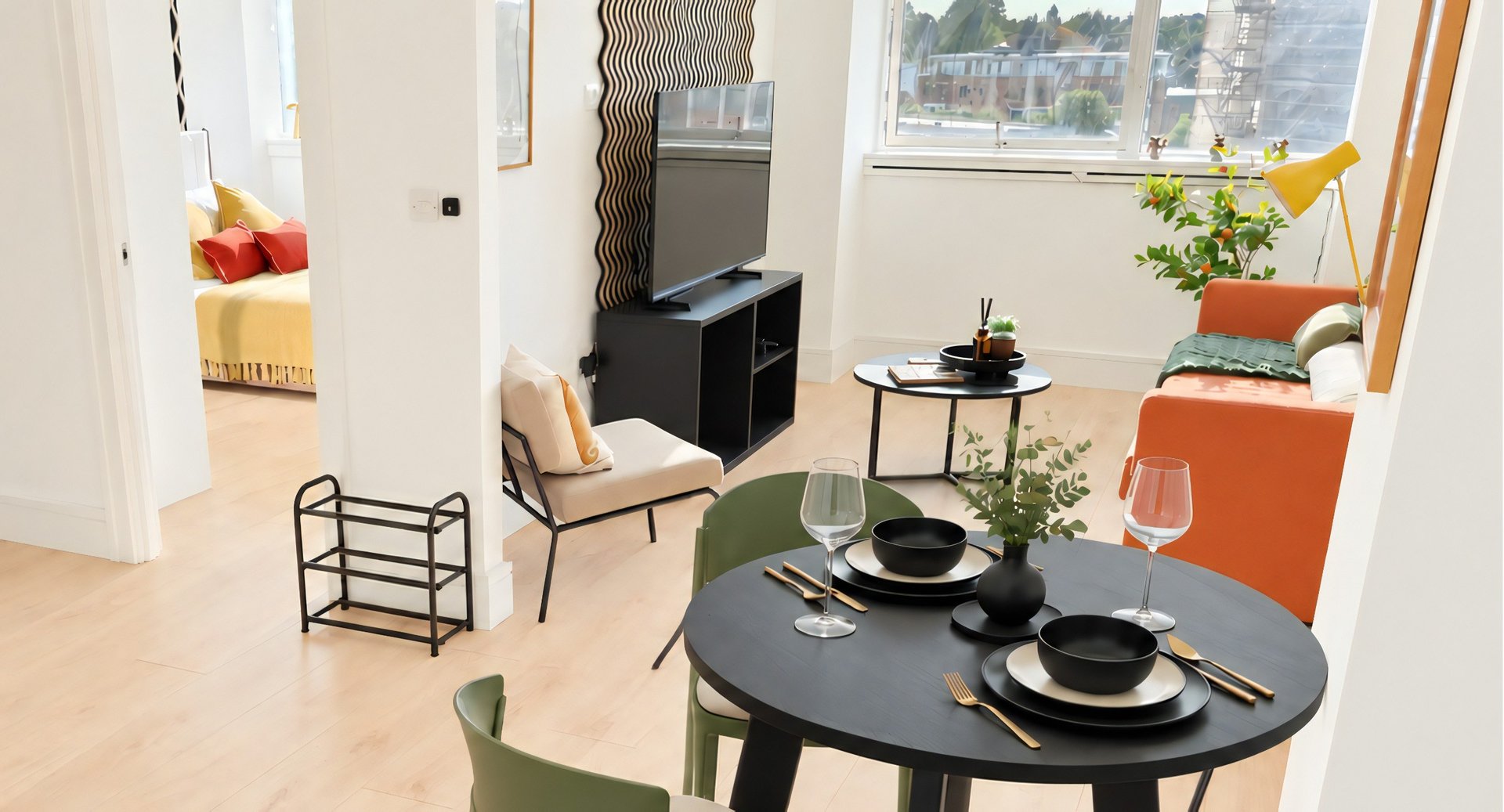 Modern open-plan living area with dining table, seating, kitchenette, and city views through windows