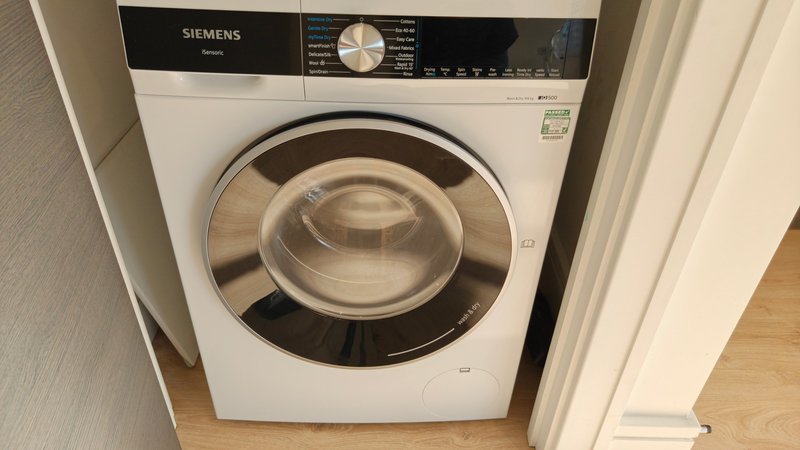 White Siemens washing machine with black control panel in utility space