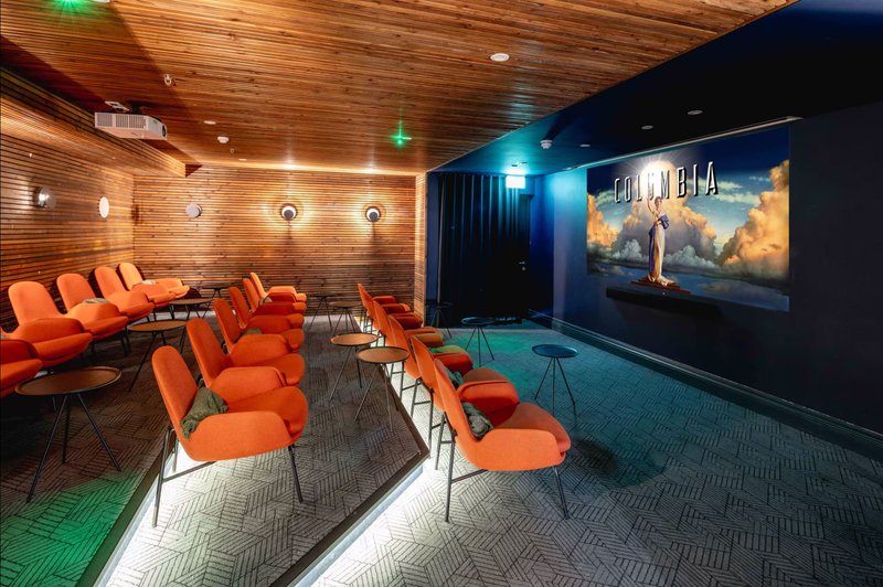 Home cinema room with orange seating, projection screen, wood ceiling and blue accent wall
