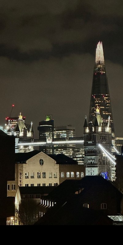 Night view of urban skyline with illuminated buildings and tall modern tower