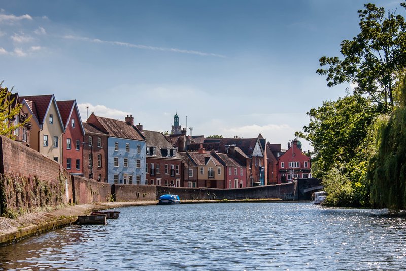 Colorful historic riverside buildings with waterfront view and moored boat