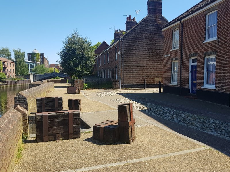 Brick terraced houses with shared courtyard, wooden seating area and paved ground
