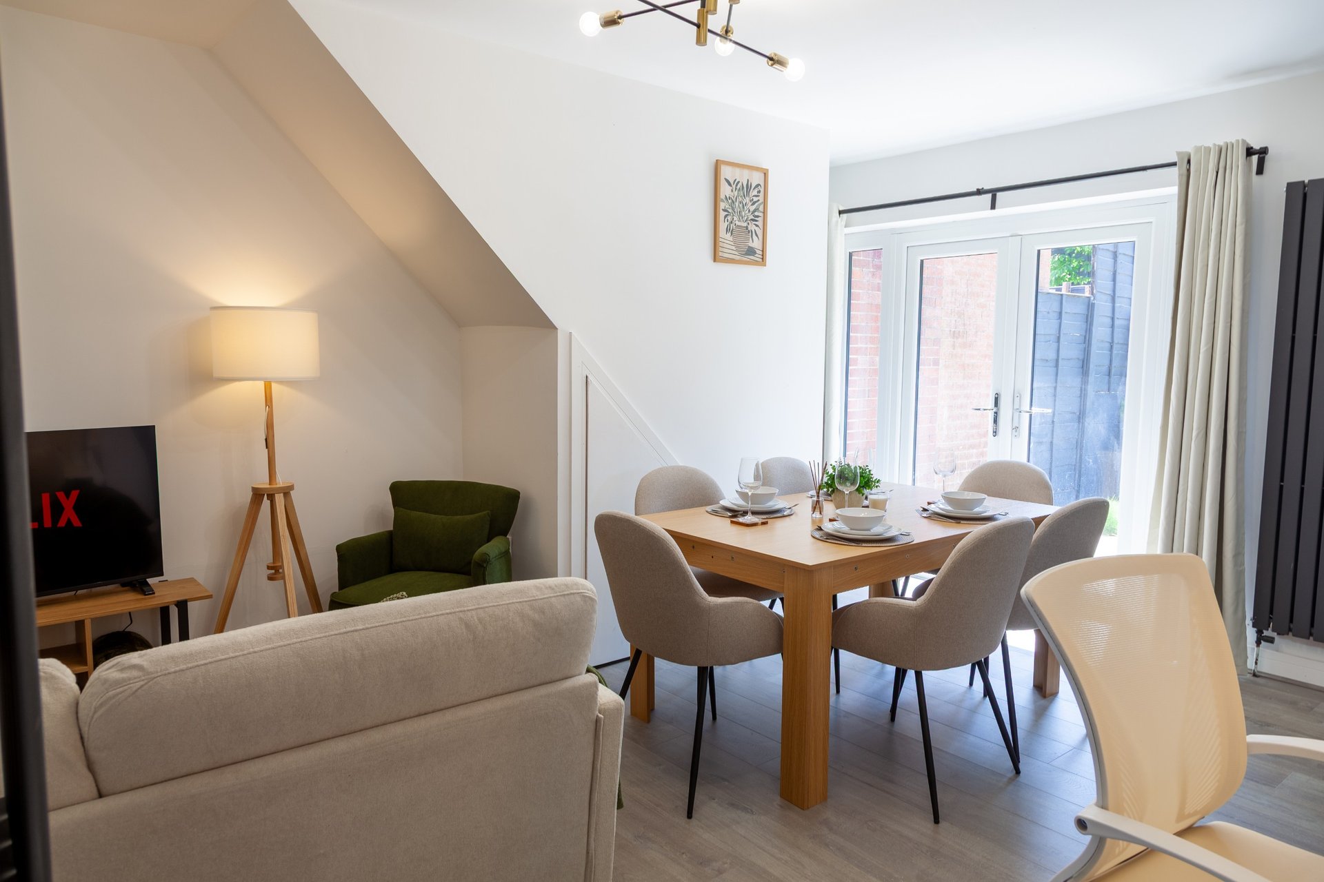 Open-plan living and dining area with sofa, dining table, chairs and patio doors
