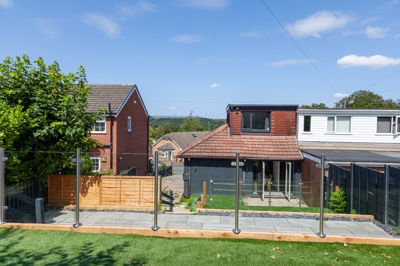 Modern brick house with garden, wooden gate, patio area and countryside views