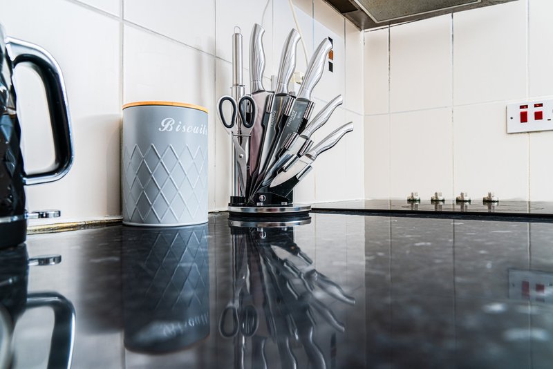 Modern kitchen countertop with utensil holder, scissors, and decorative canister