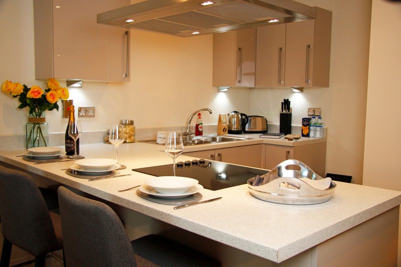 Modern kitchen with island counter, dining seating, and built-in appliances