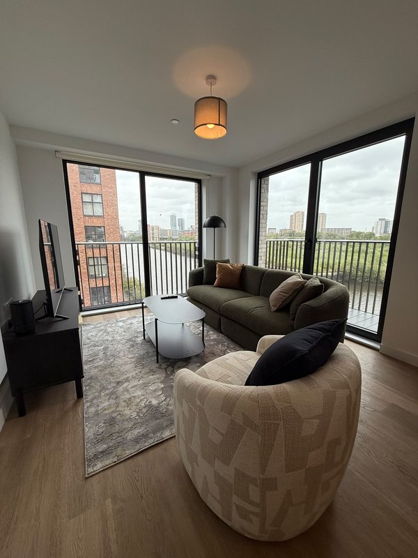 Modern living room with two sofas, pendant light, large windows overlooking city skyline