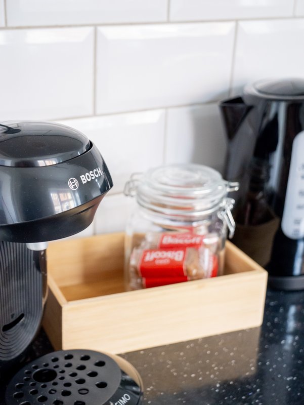 Kitchen counter with Bosch coffee maker, glass jar, and wooden storage box