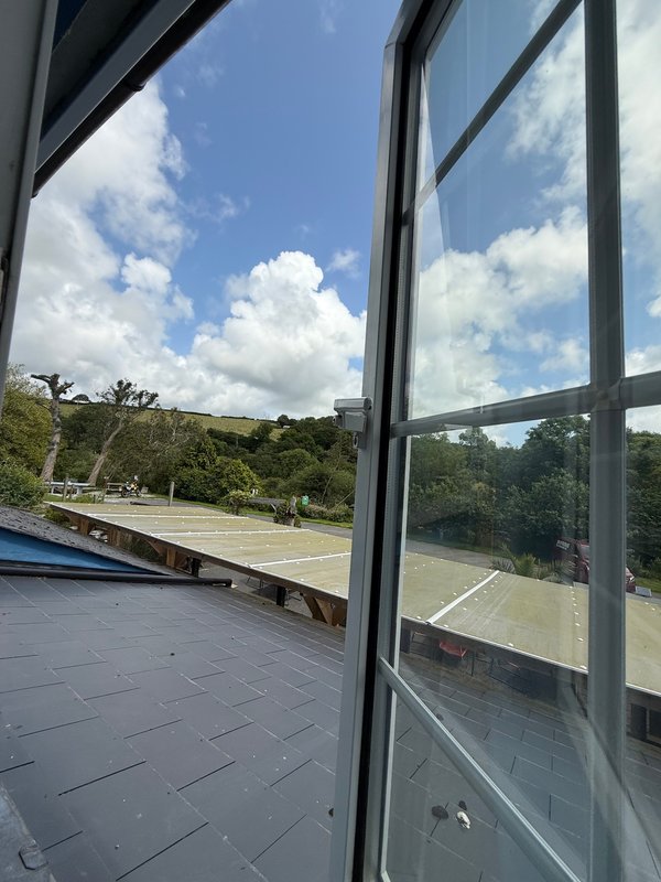 Modern patio with grey tiles, large glass doors, and scenic hillside views
