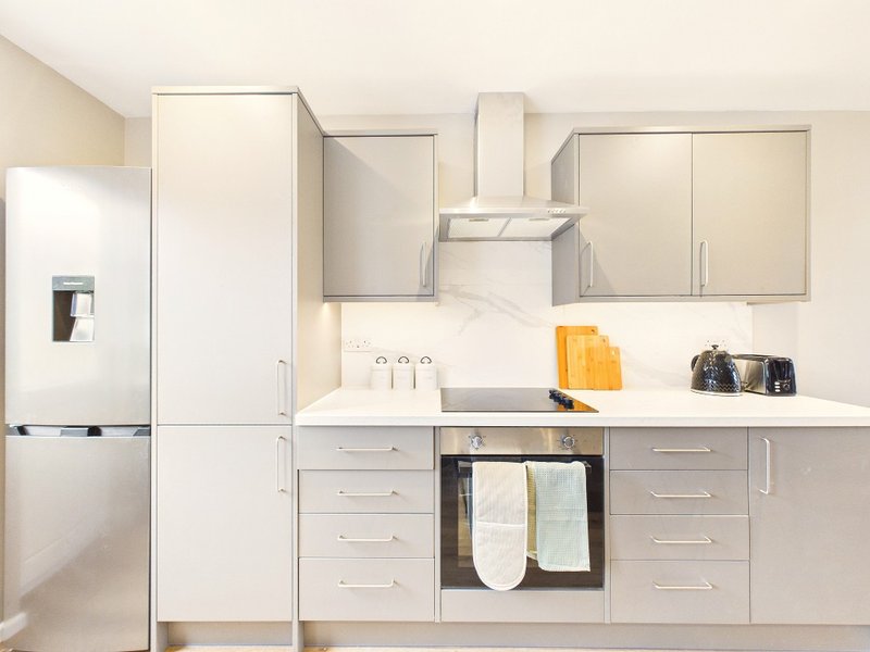 Modern kitchen with white cabinetry, stainless steel appliances, and granite countertop