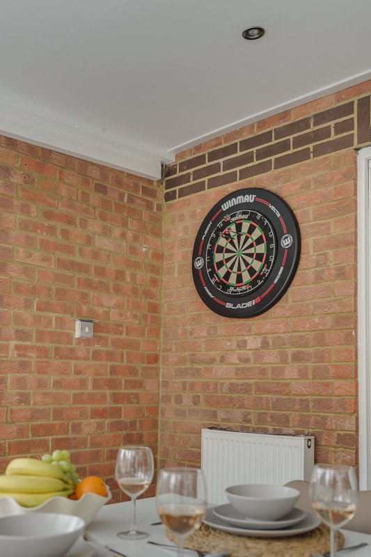 Dining area with exposed brick walls, dartboard, place settings and fresh fruit