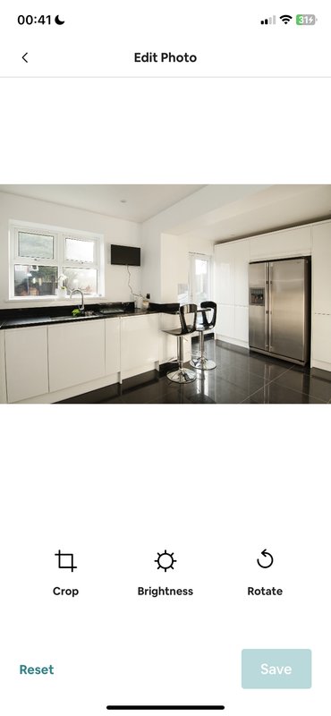 Modern white kitchen with black countertops, stainless steel appliances and island