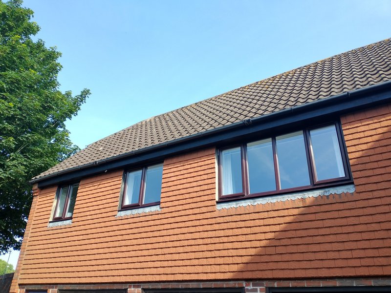 Modern timber-clad house exterior with multiple windows and tiled roof