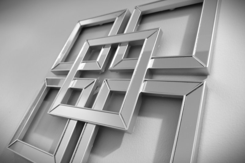 Abstract black and white photo of overlapping metal frames mounted on white wall