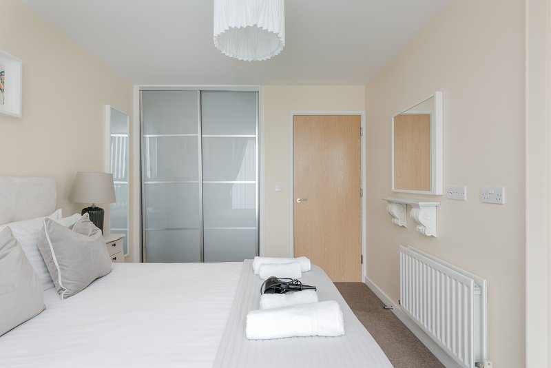Bright modern bedroom with double bed, built-in wardrobe and en-suite door