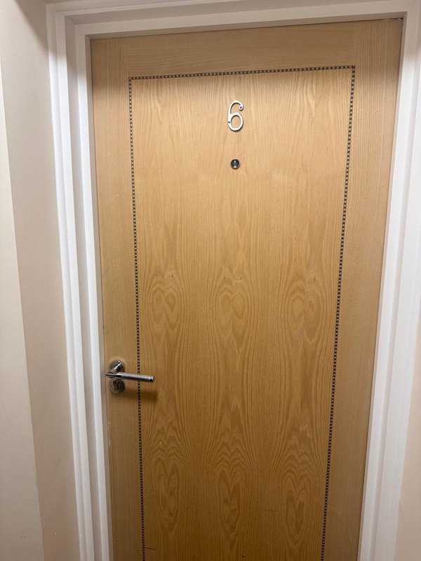 Wooden interior door with metal handle and door number six