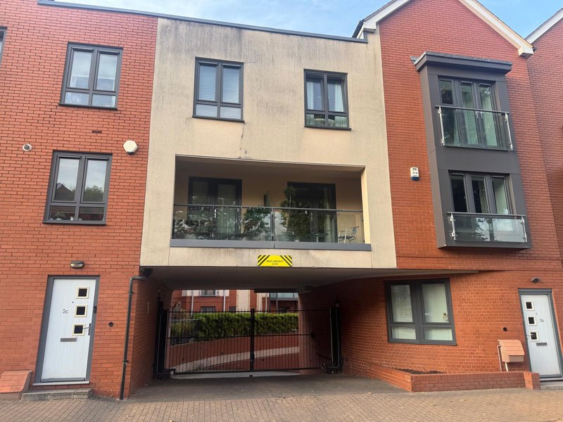Modern brick apartment building with multiple units, garage entrance, and balconies