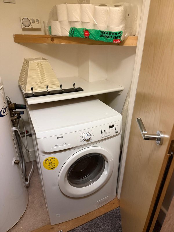 Laundry closet with washing machine, dryer, shelves with towels and cleaning supplies