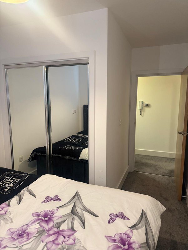 Bedroom with double bed, mirrored wardrobe, and doorway to ensuite bathroom