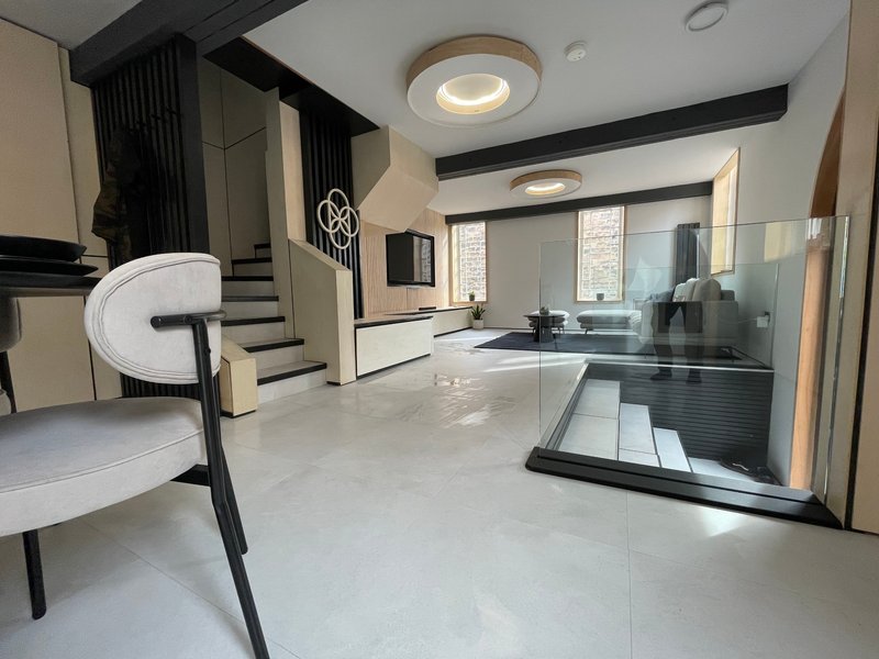 Modern open-plan interior with polished concrete flooring, kitchen area, and contemporary furnishings