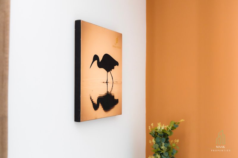 Orange and white bedroom wall with framed bird silhouette artwork and potted plant