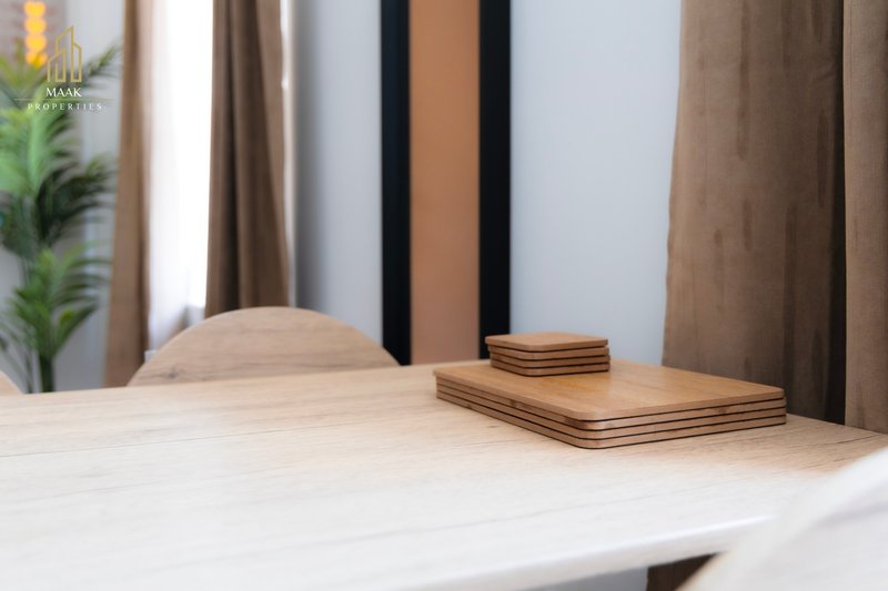 Modern desk with wooden accessories, curtains and potted plant in background
