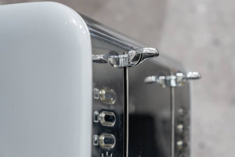 Close-up of chrome tap and black kitchen appliance with control buttons