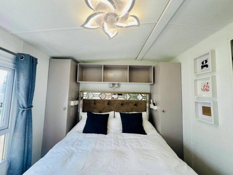 Modern bedroom with double bed, tufted headboard, built-in storage and ceiling light