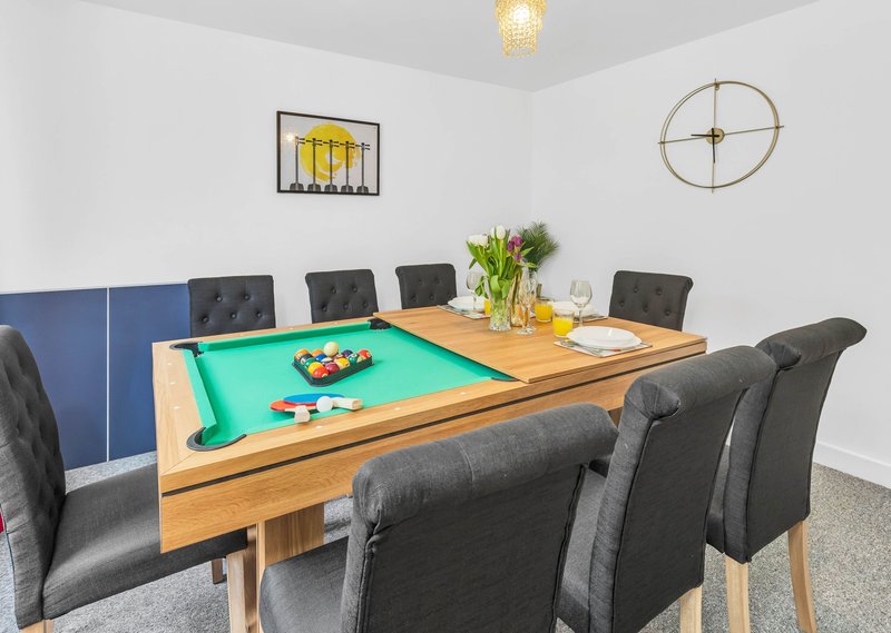 Games room with pool table, upholstered dining chairs, wall art and clock