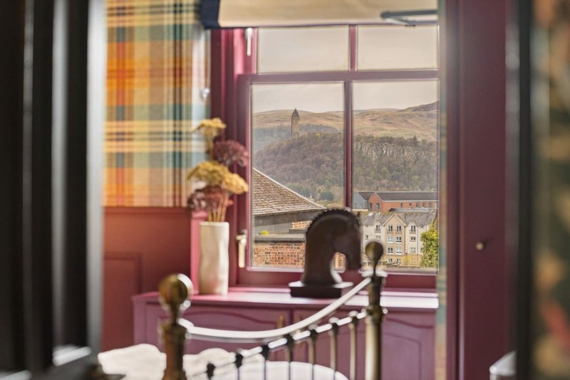 Bedroom with window overlooking historic cityscape, decorative items on windowsill