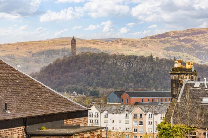 View from property overlooking valley with historic tower, forested hillside and residential buildings